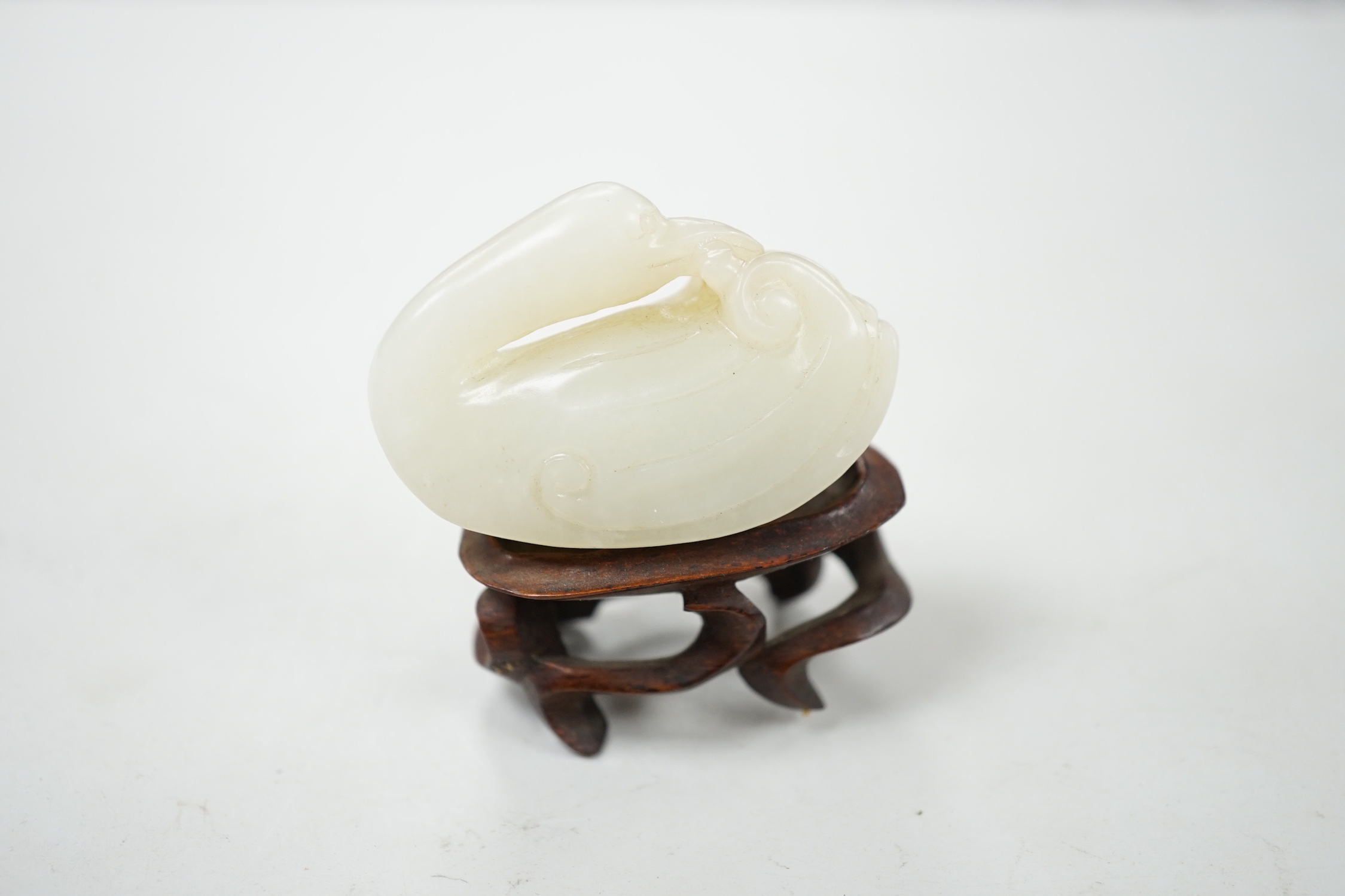 Two Chinese jades, and a wooden stand, largest jade 17.5 cm long